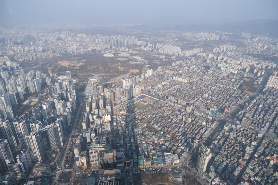 주택 임대차 신고 관련 서류와 열쇠가 놓인 테이블, 뒤편으로 도시 풍경이 보이는 이미지. 주택 임대차 계약과 관련된 중요한 절차를 상징합니다.